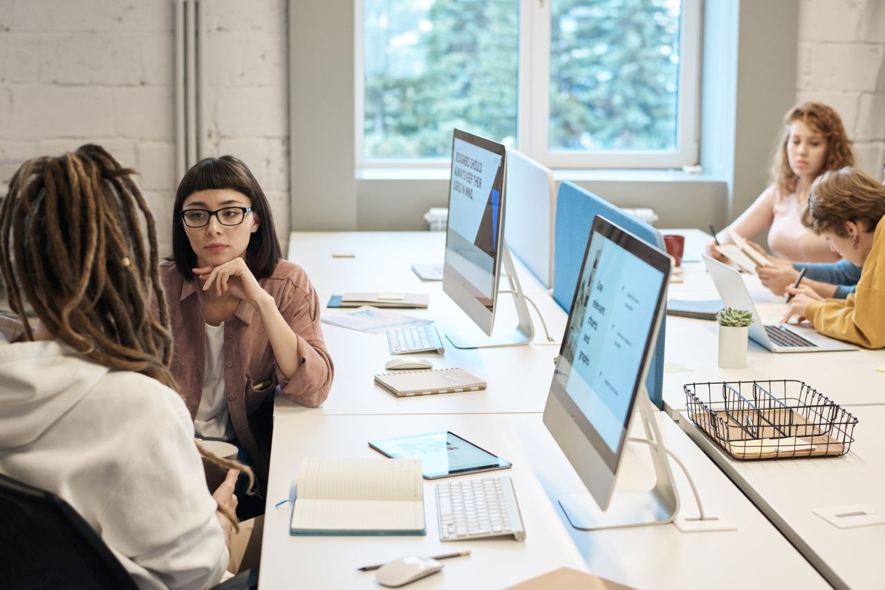 home-hero Diverse group of women working together in a modern office setting, fostering teamwork and creativity.