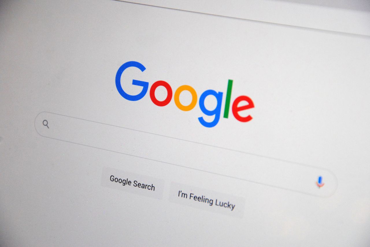 services-05 Close-up of the Google homepage on a screen showing search options.